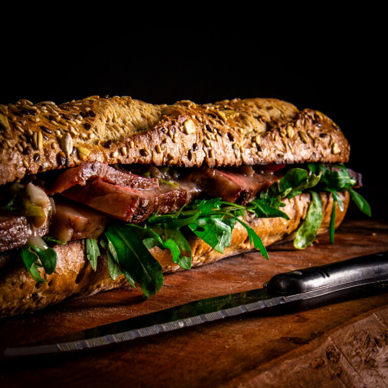 Broodje Australische ribeye van de BBQ met rucola en tomaat